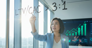 Asian female founder in a modern Singapore office calculating the LTV:CAC ratio on a whiteboard, demonstrating the financial health framework championed by Thrivemediasg.